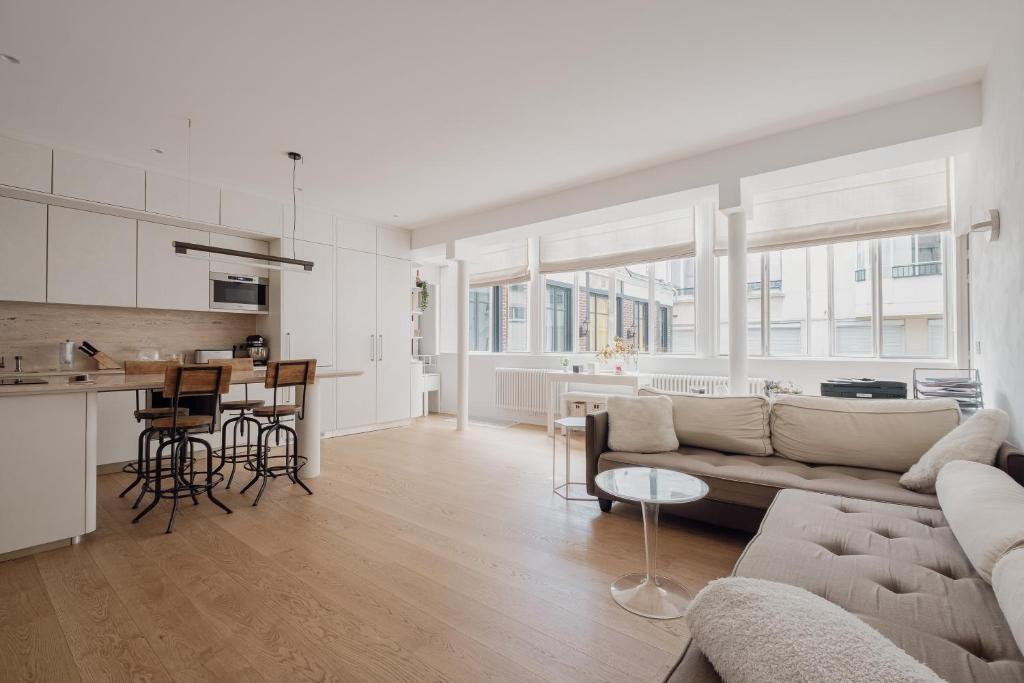 un salon et une cuisine avec un canapé et une table dans l'établissement Veeve - Sky Dreams, à Paris