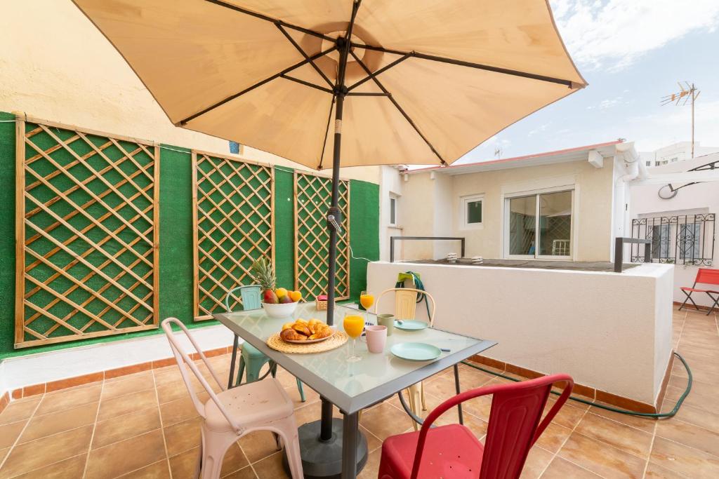 ein Tisch und Stühle mit einem Sonnenschirm auf einer Terrasse in der Unterkunft Casa Maruchi - Studio 2 in Almería