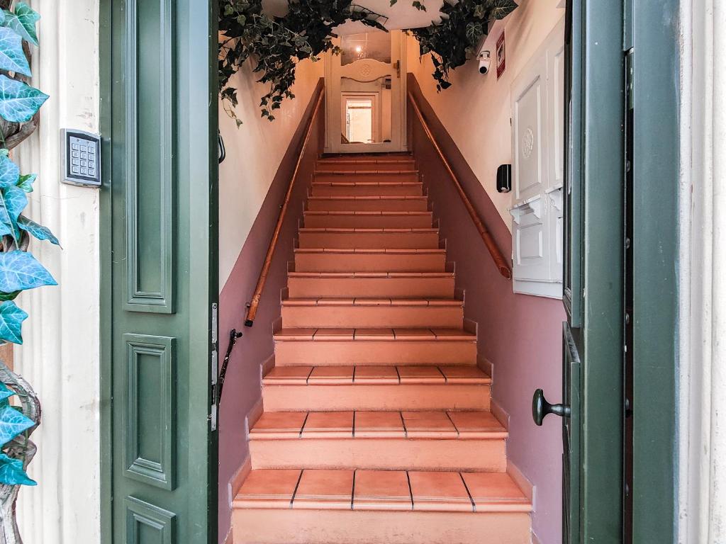a staircase in a house with a green door at Aparthotel AMMI Vieux Nice in Nice