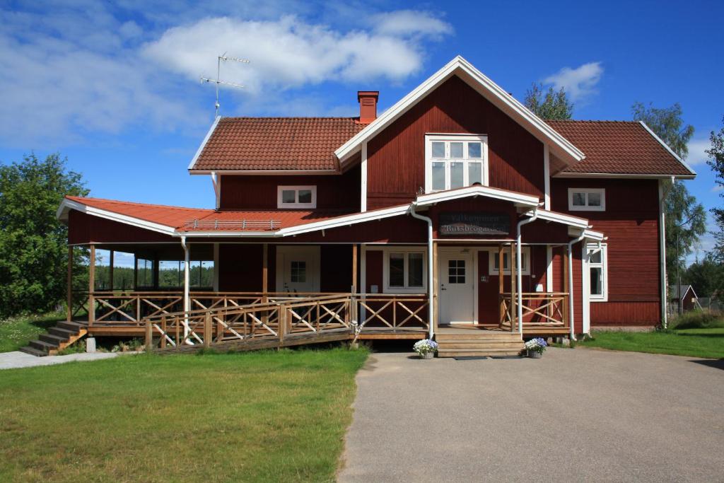 ein großes rotes Haus mit einer großen Veranda in der Unterkunft Rutsbrogården in Rutån