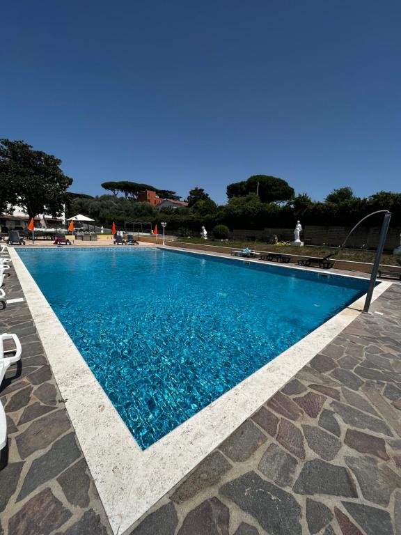 een groot zwembad met blauw water bij Villa Wuthering Heights in Rome