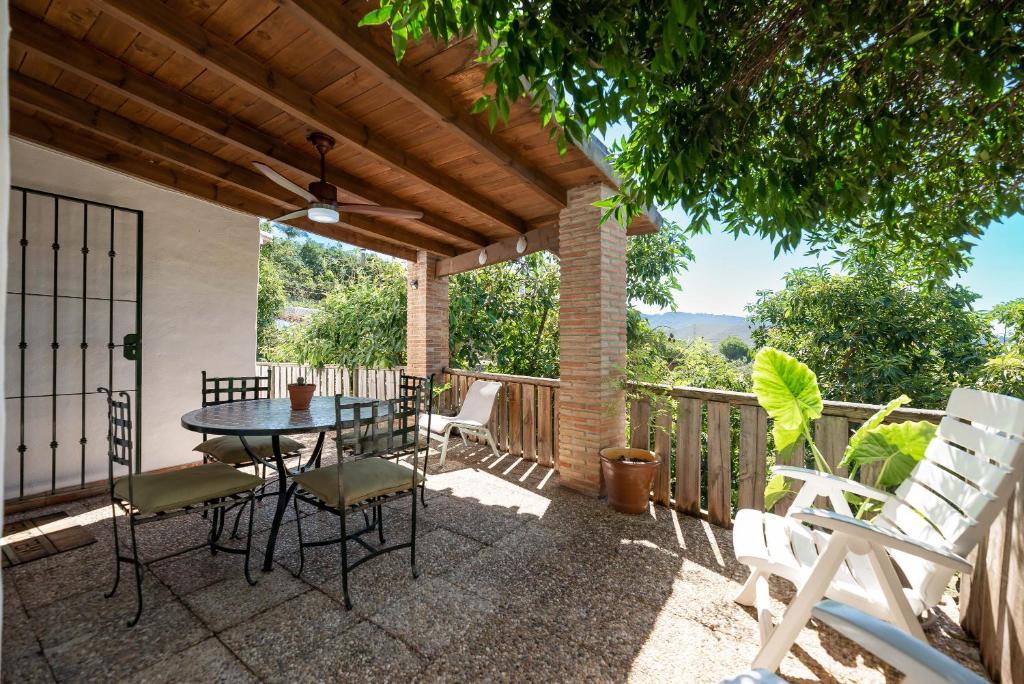 a patio with a table and chairs on a deck at Casa rural entre Ojén y Marbella in Ojén