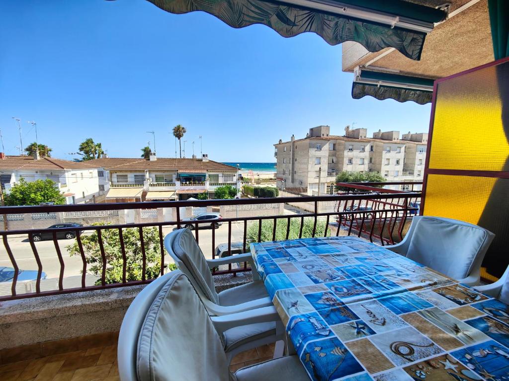 una mesa y sillas en un balcón con vistas al océano en Apartamento en la playa, en Cunit