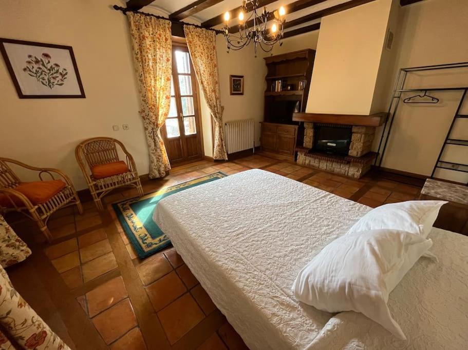 ein Schlafzimmer mit einem großen Bett und einem Kamin in der Unterkunft Casa Orbara, a 8 Km de Pamplona in Ardanaz