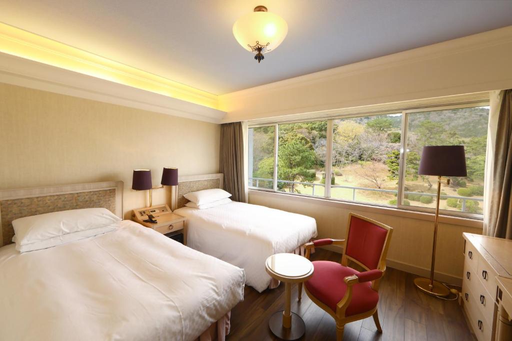 Postel nebo postele na pokoji v ubytování Kawana Hotel