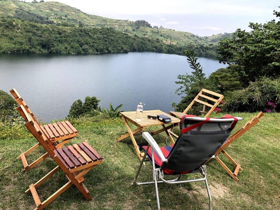 two chairs and a table next to a lake at Baranko Villa in Fort Portal