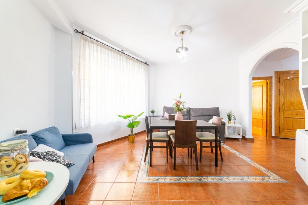 sala de estar con sofá azul y mesa en Casa Maruchi - Apartamento, en Almería