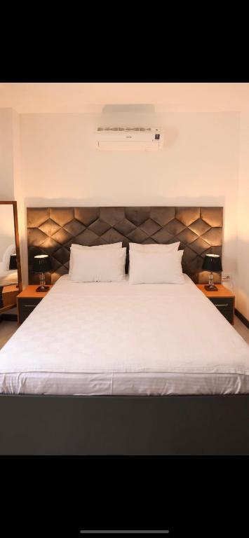 阿拉恰特的住宿－Lion Otel Alaçatı，一间卧室配有一张带两盏灯的大型白色床。