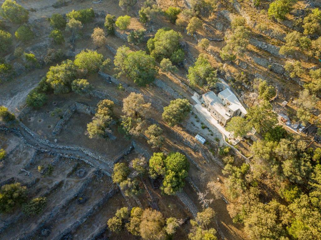 an overhead view of a forest with a building and trees at Messes Traditional Stone House with Amazing Sea View in Mandrakion