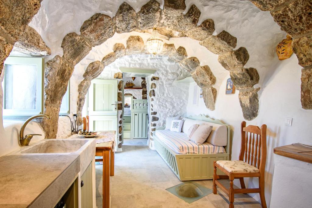 een keuken en een woonkamer met een stenen boog bij Messes Traditional Stone House with Amazing Sea View in Mandrákion