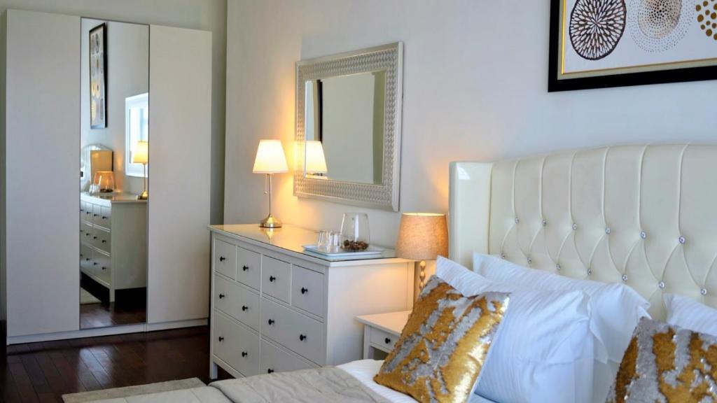 a bedroom with a bed and a dresser and a mirror at Lucky Tower Residence 2BR Top Floor Condo in Jakarta