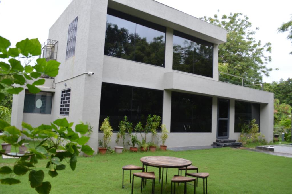 ein Haus mit einem Tisch und Stühlen davor in der Unterkunft VSP's Villa - Kensville Golf Living in Nānodra