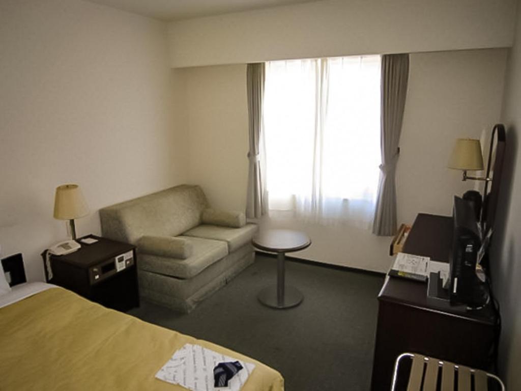 um quarto de hotel com uma cama e um sofá em Ichihara Marine Hotel - Vacation STAY 01363v em Ichihara