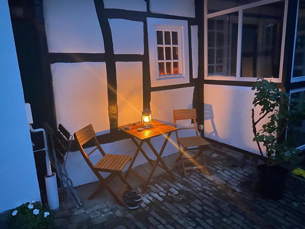 une table et des chaises assises sur le côté d'une maison dans l'établissement Scheunentraum Brenig, à Bornheim