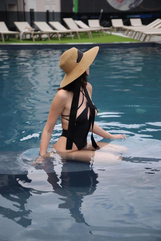 a woman in a hat sitting in a swimming pool at Premium hotel & SPA in Bukovel