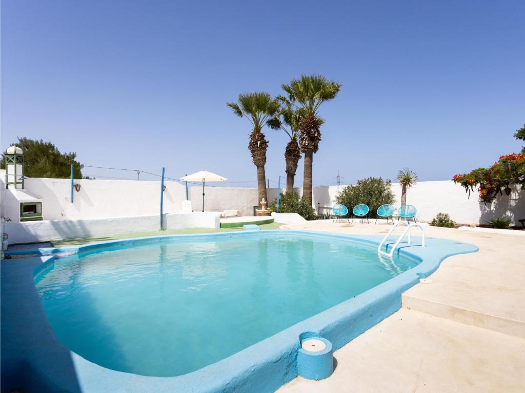 a swimming pool with blue water and palm trees at Live Socorro Juan Fu Rural in Güimar