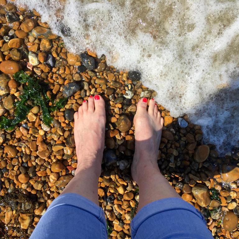 a persons feet on the rocks on the beach at The Bubble Hideaway - A Little Oasis near the Sea in Whitstable