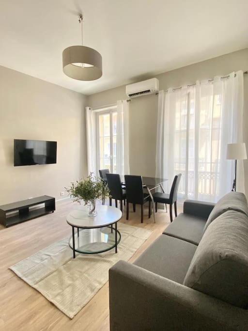 un soggiorno con un divano e un tavolo di Appartement au coeur de Nice pour 4 - Clim & Wifi a Nizza