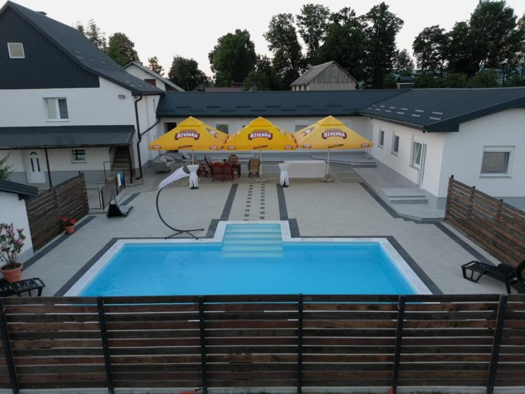 a large swimming pool with umbrellas on top of it at Apartmani Albatros in Perušić