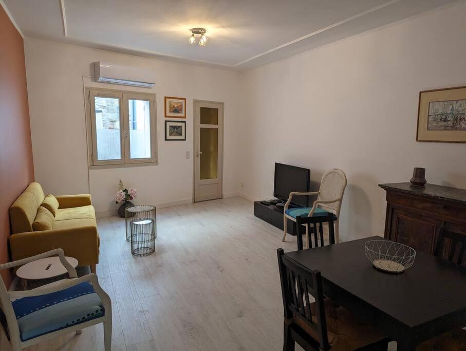 a living room with a couch and a table at Appartement Cosy centre ville in LʼIsle-sur-la-Sorgue