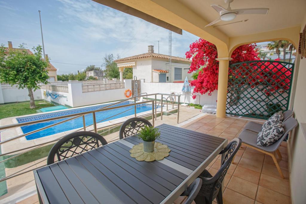 un patio con mesa, sillas y piscina en ADAPTADOS 4 en Vinarós