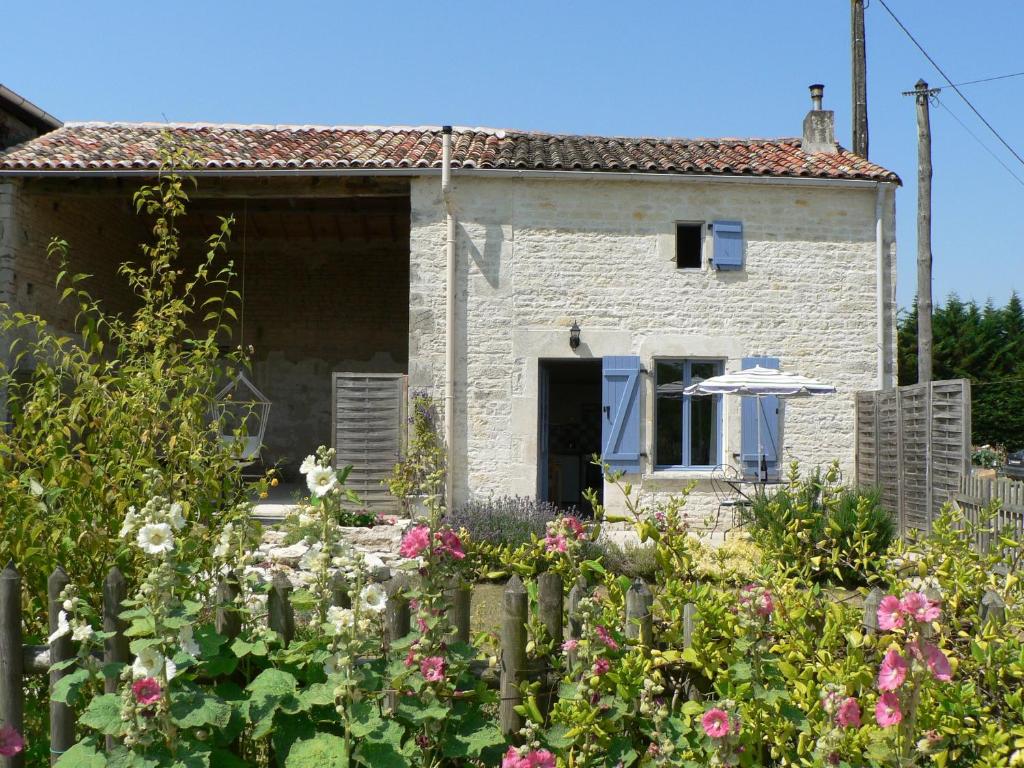 a stone house with a garden in front of it at La Petite Maison in Crézières