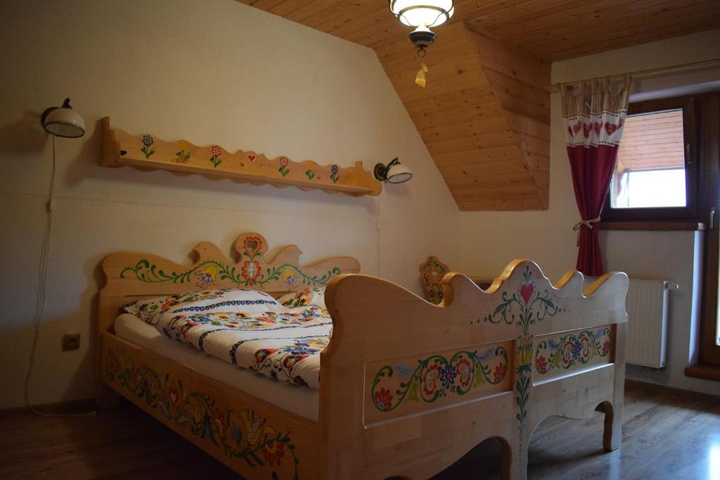 Dormitorio infantil con cama de madera en una habitación en Penzión na gazdovskom dvore, en Dolný Kubín
