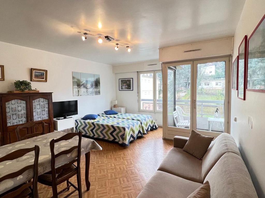 ein Wohnzimmer mit einem Sofa, einem Bett und einem Tisch in der Unterkunft Studio Aix-les-Bains, 1 pièce, 2 personnes - FR-1-555-38 in Aix-les-Bains