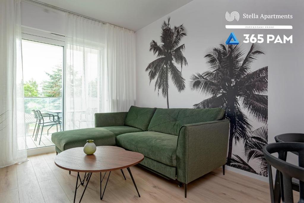a living room with a green couch and a table at Hawaje apartament przy plaży - 365PAM in Sianozety