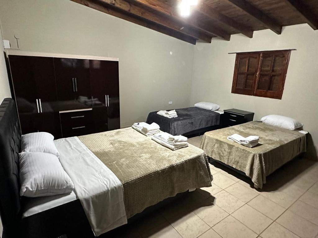 a hotel room with two beds and two tables at Depto Villa Unión I in Villa Unión