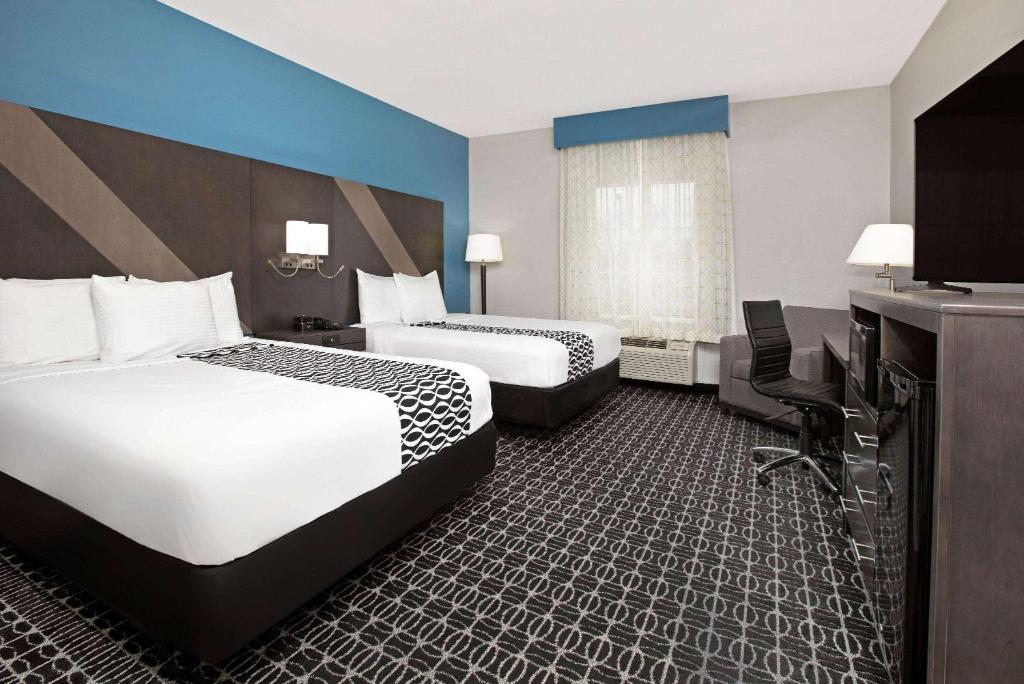 a hotel room with two beds and a television at La Quinta by Wyndham Sulphur Springs in Sulphur Springs