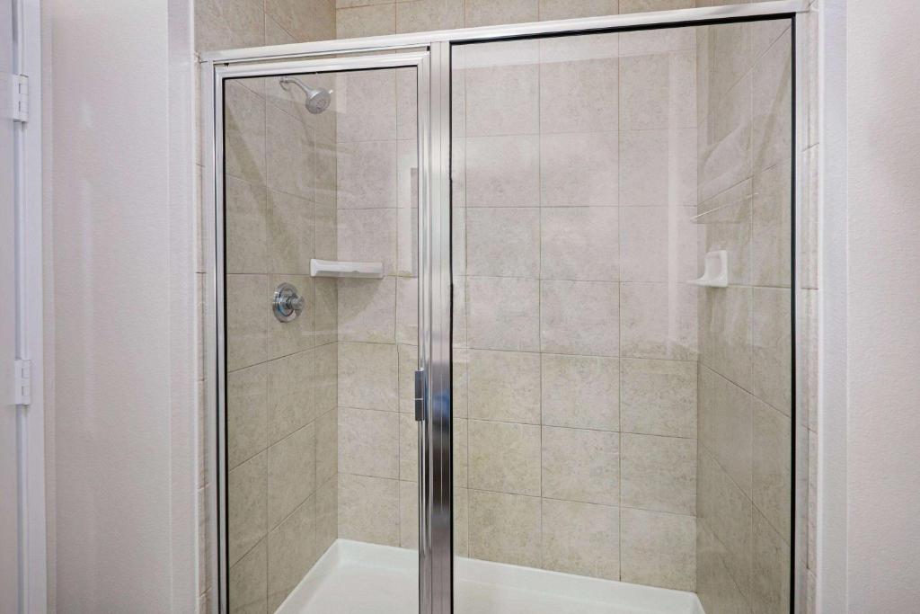 a shower with a glass door in a bathroom at La Quinta by Wyndham Sulphur Springs in Sulphur Springs