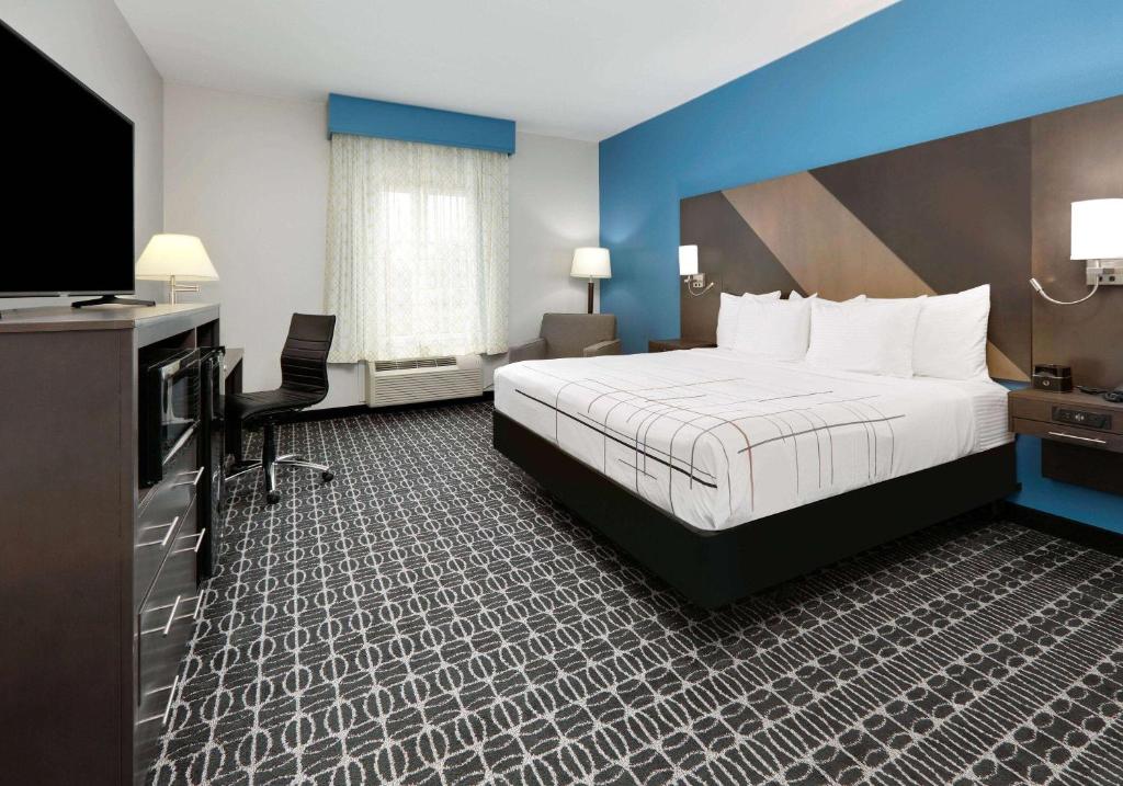 a hotel room with a bed and a flat screen tv at La Quinta by Wyndham Sulphur Springs in Sulphur Springs