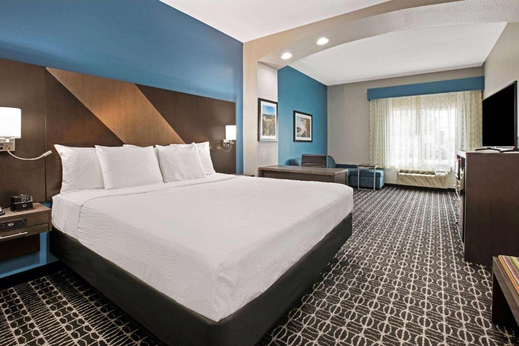 a hotel room with a large bed and a television at La Quinta by Wyndham Sulphur Springs in Sulphur Springs