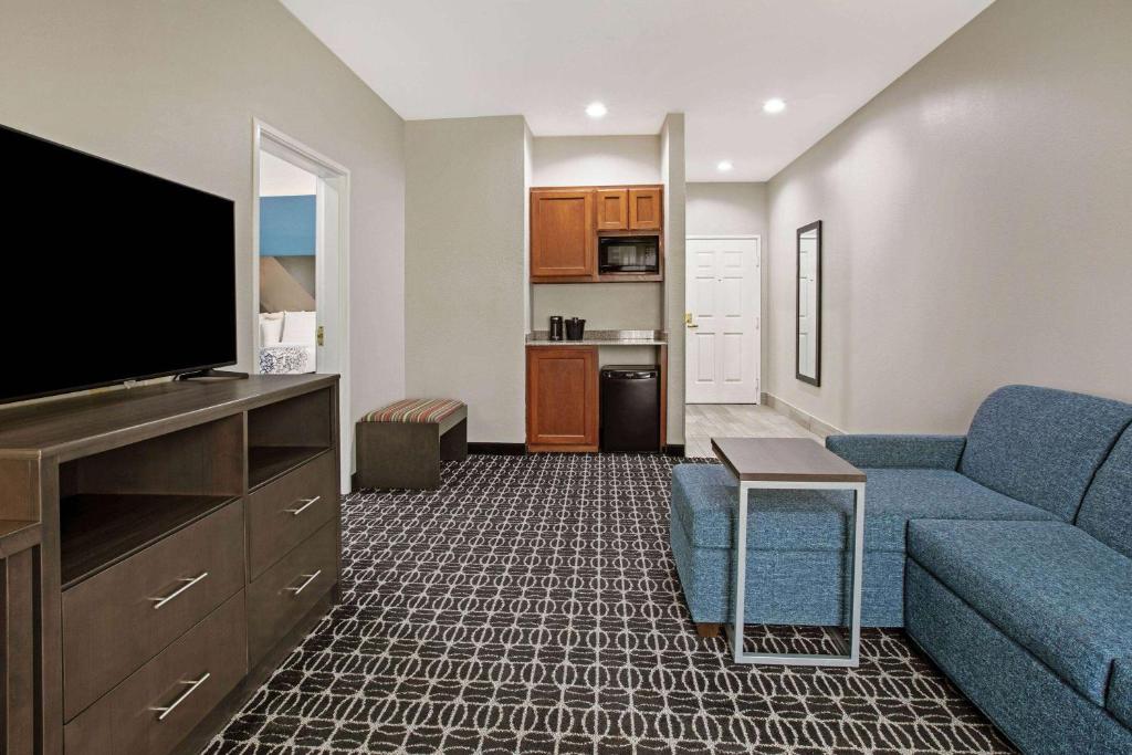 a living room with a couch and a flat screen tv at La Quinta by Wyndham Sulphur Springs in Sulphur Springs