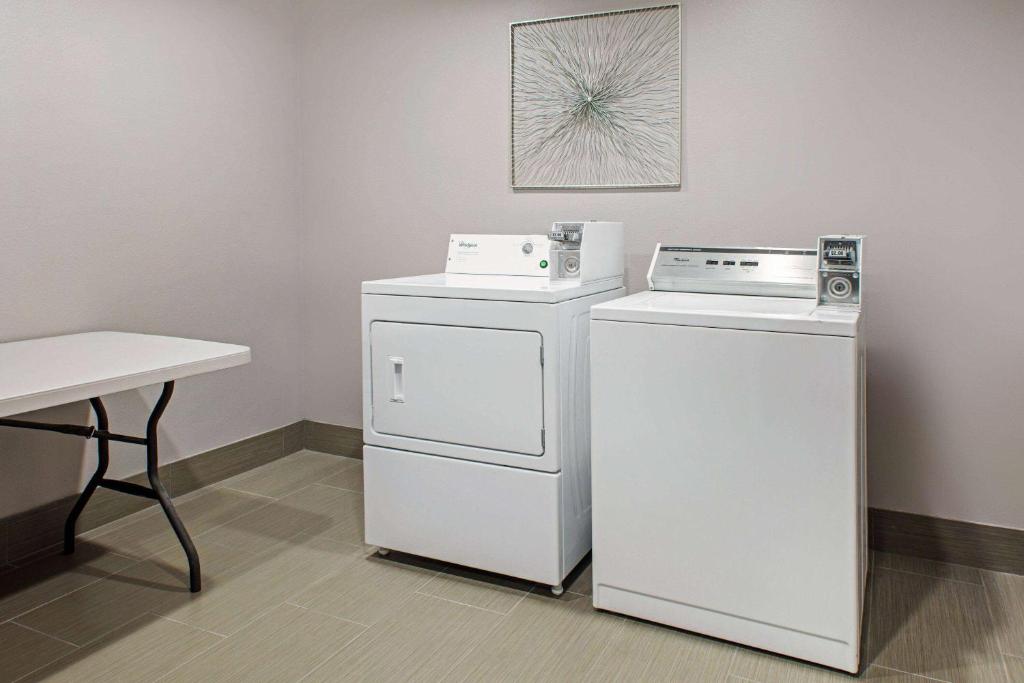 a laundry room with two machines and a table at La Quinta by Wyndham Sulphur Springs in Sulphur Springs