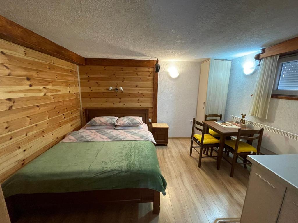 een slaapkamer met een bed, een bureau en een tafel bij Zabljak studio apartment 2 in Žabljak