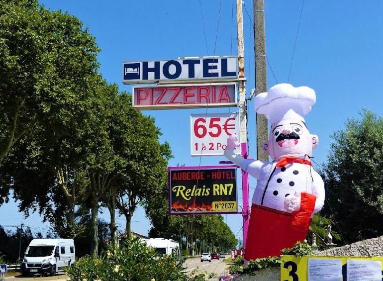 a sign for a hotel with a snowman on it at Le Relais de la RN7 in Châteauneuf-du-Rhône