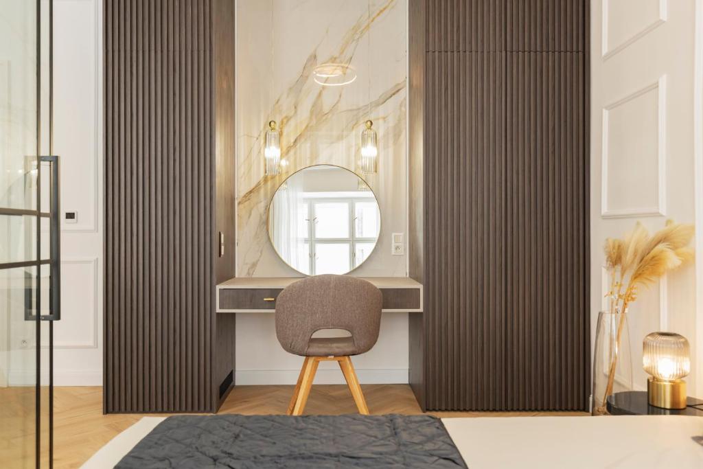 a dressing room with a chair and a mirror at GENeve - old town apartment Bratislava in Bratislava