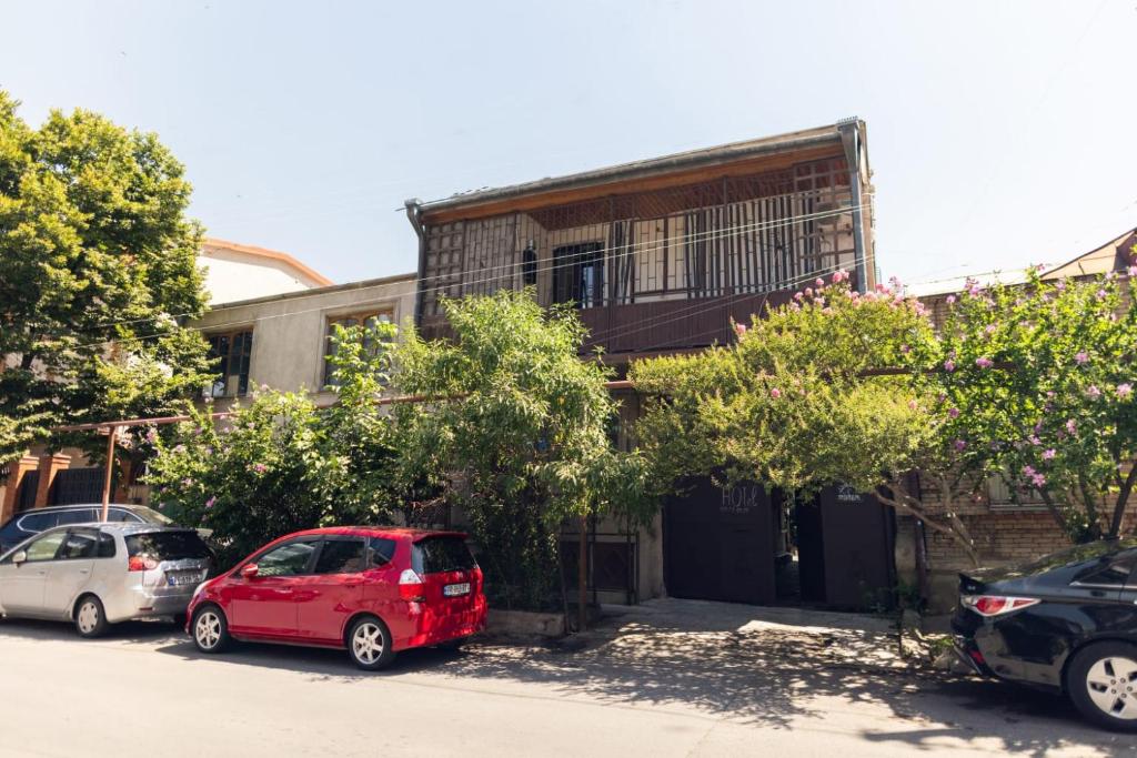 dos coches estacionados frente a un edificio en Wine House en Tiflis