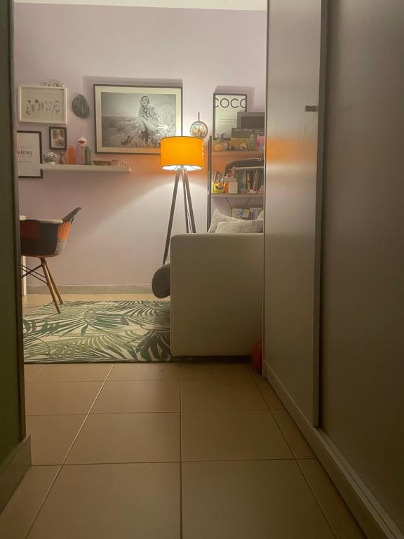 een woonkamer met een bank en een lamp bij Appartamento vista mare in Copanello