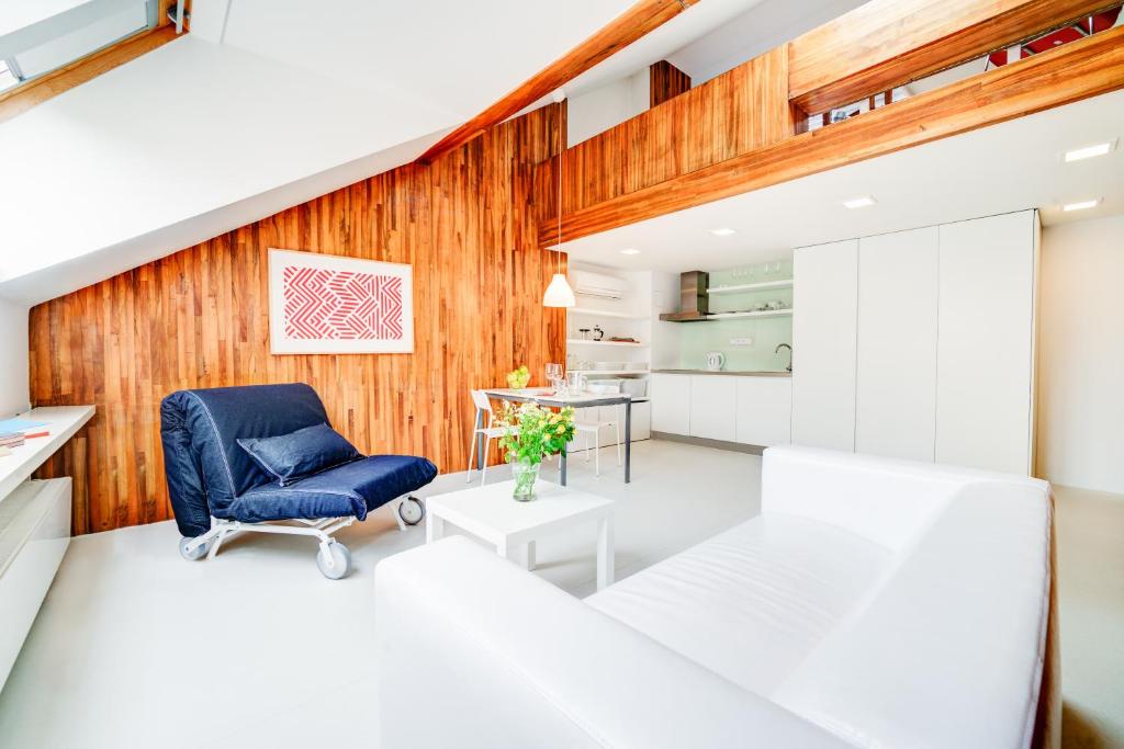 una sala de estar con una silla azul y paredes de madera. en Happy Apartment, en Brno