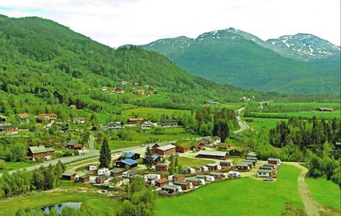 een klein dorpje in een vallei met bergen bij Midttun Camping og Feriehytter in Vossestrand