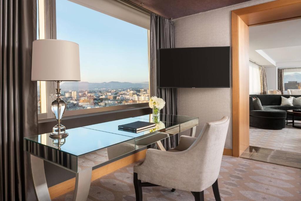 a desk and chair in a room with a window at The Ritz-Carlton, Los Angeles L.A. Live in Los Angeles