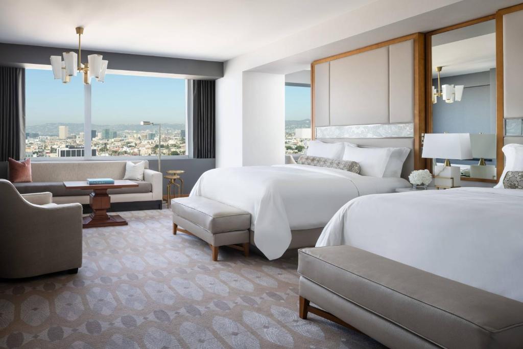 a hotel room with two beds and a couch at The Ritz-Carlton, Los Angeles L.A. Live in Los Angeles