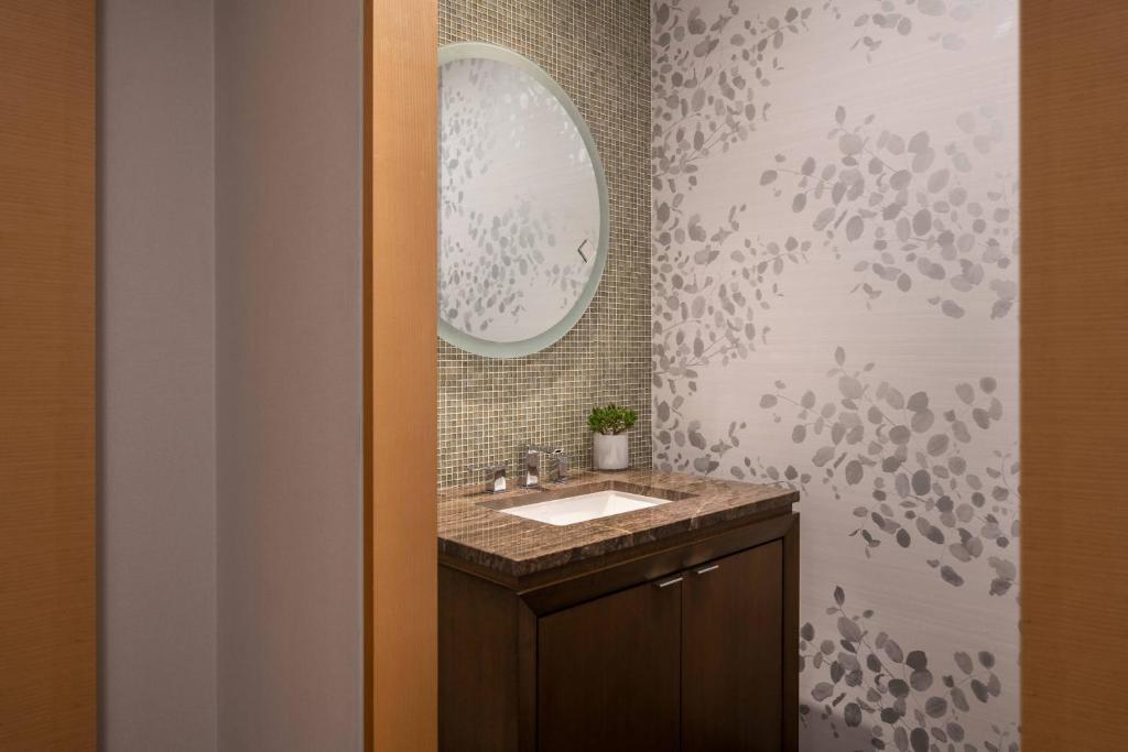 a bathroom with a sink and a mirror at The Ritz-Carlton, Los Angeles L.A. Live in Los Angeles