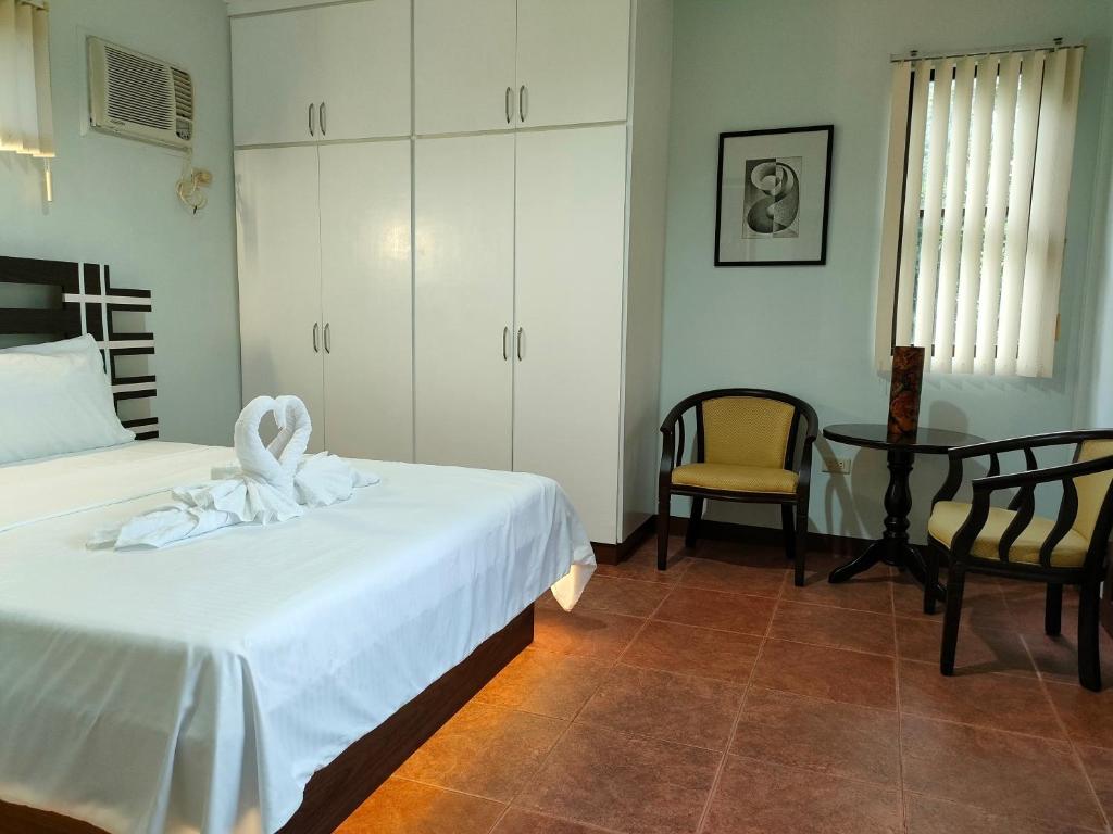 sypialnia z 2 łóżkami, stołem i krzesłem w obiekcie DMC2 Residence Panglao w Panglao City
