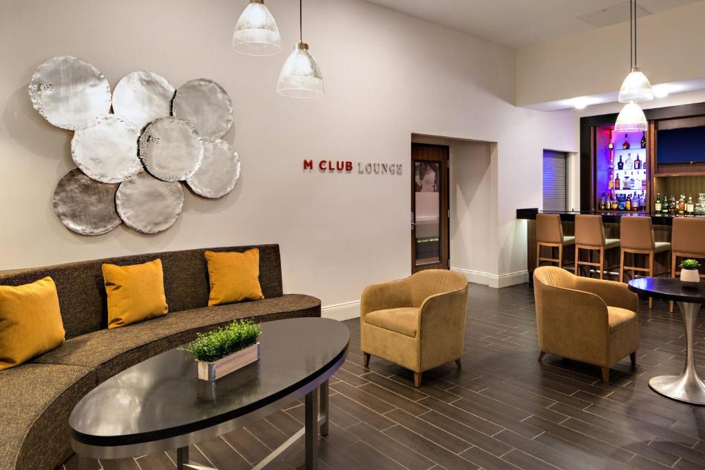 a living room with a couch and a table and a bar at Houston Marriott South at Hobby Airport in Houston