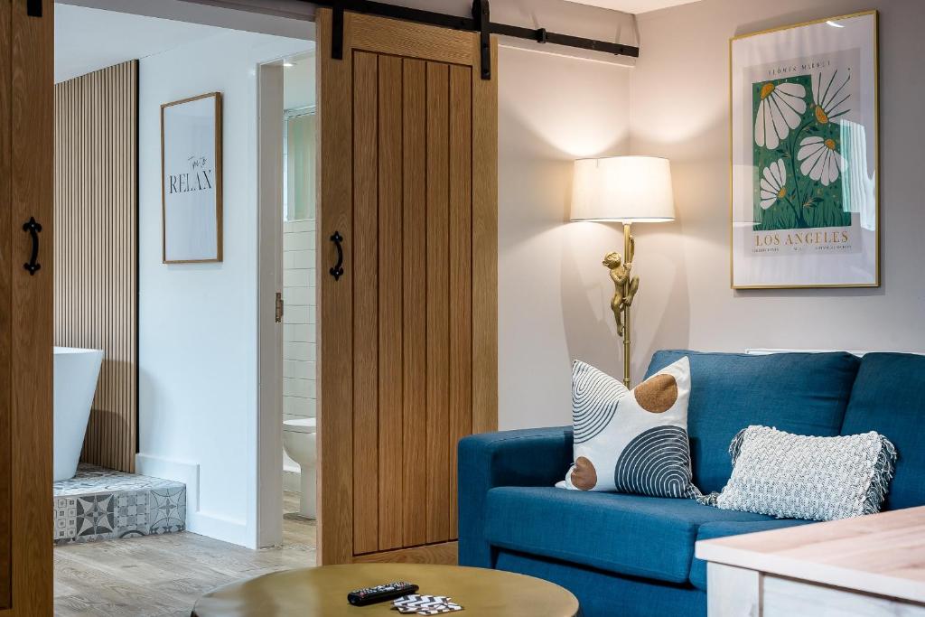 un soggiorno con divano blu e tavolo di Host & Stay - The Georgian Coach House 2 a Liverpool