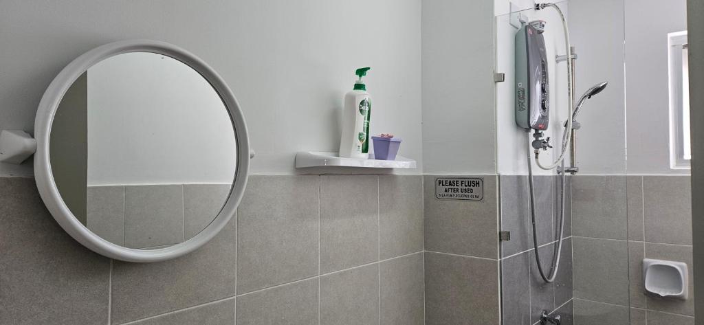a bathroom with a round mirror and a shower at E. R Homestay 3R2B nearby KLIA in Sepang